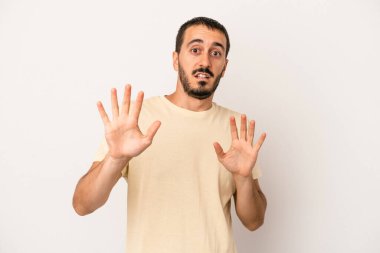 Beyaz arka planda izole genç beyaz adam yakın bir tehlike nedeniyle şoka uğruyor