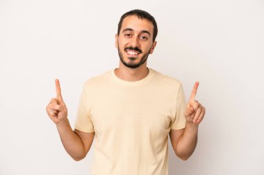 Beyaz arka planda izole genç beyaz adam işaret iki ön parmakları boş bir boşluk gösteren.