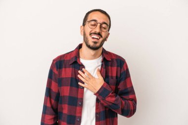 Beyaz arka planda izole genç beyaz adam yüksek sesle gülüyor elini göğsüne koyuyor..