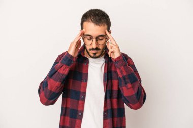 Beyaz arka planda izole edilmiş genç beyaz bir adam tapınaklara dokunuyor ve başı ağrıyor..