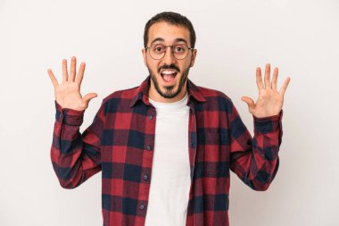 Beyaz arka planda izole genç beyaz adam hoş bir sürpriz alıyor, heyecanlı ve el kaldırıyor..