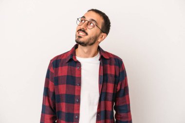 Beyaz arka planda izole edilmiş genç beyaz adam gevşemiş ve mutlu bir şekilde gülüyor, boynunda dişlerini gösteriyor..