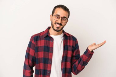 Beyaz arka planda izole edilmiş genç beyaz bir adam bir palmiye üzerinde fotokopi alanı gösteriyor ve belinde başka bir el tutuyor..