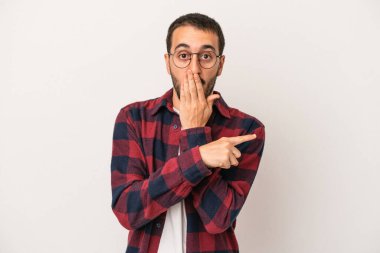 Beyaz arka planda izole edilmiş genç beyaz adam yan tarafı işaret ediyor