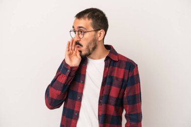 Beyaz arka planda izole edilmiş genç beyaz adam gördüğü bir şey yüzünden şoka uğruyor..