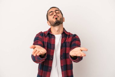 Beyaz arka planda izole edilmiş genç beyaz bir adam dudaklarını katlıyor ve hava öpücüğü vermek için avuç içleri tutuyor..
