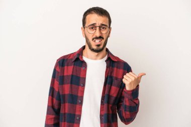 Beyaz arka planda izole edilmiş genç beyaz bir adam işaret parmağıyla fotokopi alanını işaret ederek şok oldu..