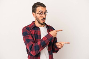 Beyaz arka planda izole edilmiş genç beyaz bir adam işaret parmağıyla fotokopi alanını işaret ederek heyecan ve arzusunu ifade ediyor..