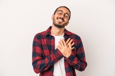 Beyaz arka planda izole edilmiş beyaz tenli genç bir adam, dostane bir ifadeye sahip, avuçlarını göğsüne bastırıyor. Aşk konsepti.