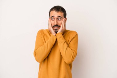 Beyaz arka planda izole edilmiş genç beyaz adam korkmuş ve korkmuş..