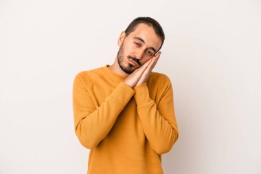 Beyaz arka planda izole edilmiş genç beyaz adam esniyor. Ağzı eliyle kapatan yorgun bir hareket sergiliyor..