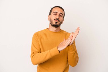 Beyaz arka planda izole olmuş genç beyaz bir adam enerjik ve rahat hissediyor, ellerini ovuşturuyor..