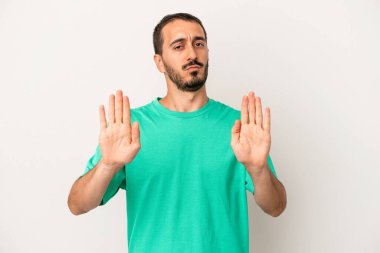 Beyaz arka planda izole edilmiş genç beyaz bir adam elini uzatmış, dur işareti göstererek seni engelliyor..