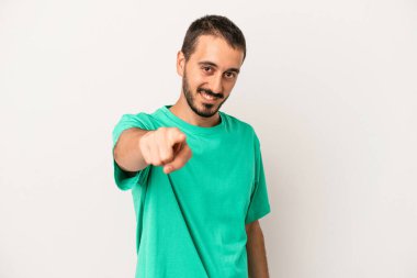 Beyaz arka planda soyutlanmış beyaz tenli genç adam öne bakan neşeli gülümsemeler..