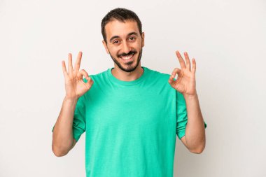 Beyaz arka planda izole edilmiş genç beyaz bir adam neşeli ve kendinden emin..