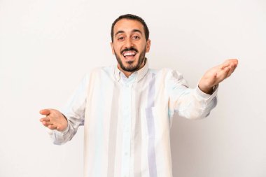 Beyaz arka planda izole edilmiş genç beyaz adam kameraya sarıldığı için kendinden emin hissediyor..