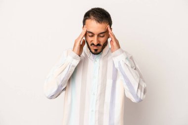 Beyaz arka planda izole olmuş genç beyaz bir adam başı ağrıyor, yüzüne dokunuyor..
