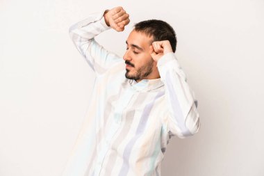 Beyaz arka planda izole genç beyaz adam özel bir günü kutluyor, atlıyor ve enerjiyle kollarını kaldırıyor..