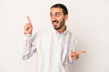 Beyaz arka planda izole edilmiş genç beyaz bir adam farklı kopya alanlarını gösteriyor, birini seçiyor, parmaklarıyla gösteriyor..