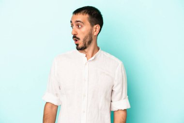 Kafkasyalı genç adam mavi arka planda izole edilmişti. Gördüğü bir şey yüzünden şok olmuştu..