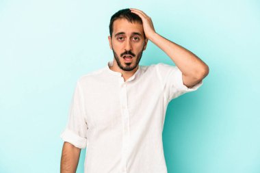 Mavi arka planda izole genç beyaz adam şok oldu, o önemli bir toplantı hatırladı.