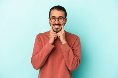 Kafkasyalı genç adam mavi arka planda izole edilmiş iki seçenek arasında şüphe duyuyor.