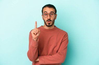 Kafkasyalı genç adam mavi arka planda izole edildi. Harika bir fikri var, yaratıcılık kavramı..