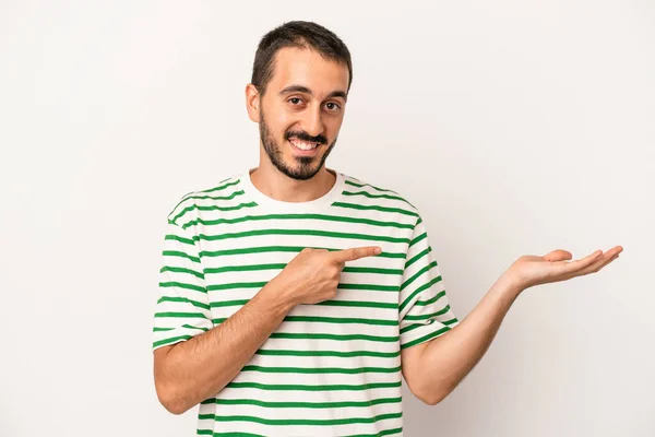 Jovem Caucasiano Isolado Fundo Branco Animado Segurando Espaço Cópia Palma — Fotografia de Stock