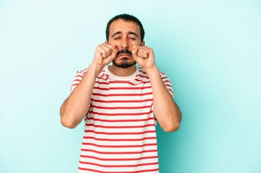 Kafkasyalı genç adam mavi arka planda izole edilmiş sızlanıyor ve ağlıyordu..