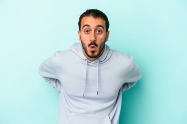 Kafkasyalı genç adam mavi arka planda izole edilmişti. Gördüğü bir şey yüzünden şok olmuştu..