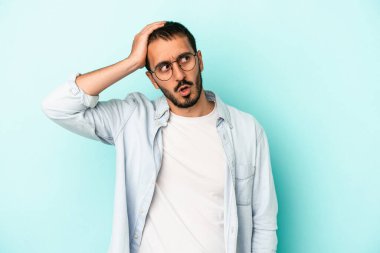 Mavi arka planda izole genç beyaz adam şok oldu, o önemli bir toplantı hatırladı.