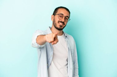 Mavi arka planda izole edilmiş genç beyaz adam öne bakan neşeli gülümsemeler.