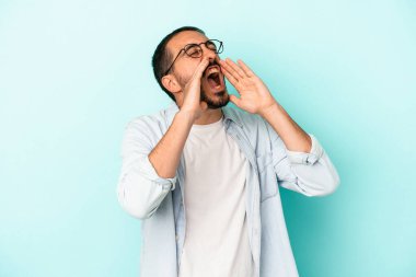 Mavi arka planda izole edilmiş beyaz bir adam heyecanlı bir şekilde bağırıyor..