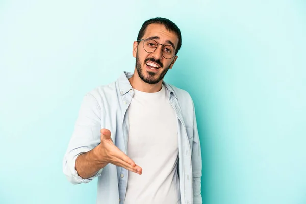 Joven Hombre Caucásico Aislado Sobre Fondo Azul Estirando Mano Cámara — Foto de Stock