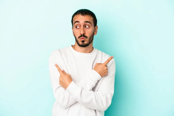 Young Caucasian Man Isolated Blue Background Points Sideways Trying Choose — Stock Photo, Image