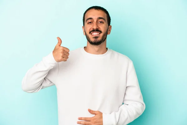 Young Caucasian Man Isolated Blue Background Touches Tummy Smiles Gently — Stock Photo, Image