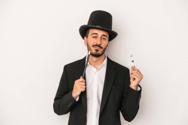 Genç sihirbaz sihirli değnek ve sihirli kartı beyaz arka planda tutuyor.