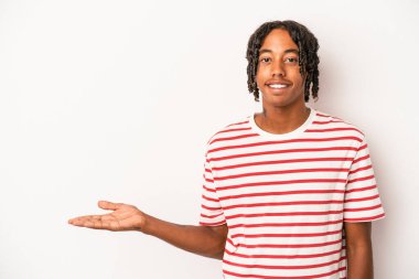 Beyaz arka planda izole edilmiş genç Afro-Amerikalı bir adam bir avuç içinde fotokopi alanı gösteriyor ve belinde başka bir el tutuyor..