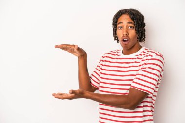 Beyaz arka planda izole edilmiş genç bir Afro-Amerikan erkeği ellerinin arasında bir kopya alanı tutarken şok ve hayrete düştü..