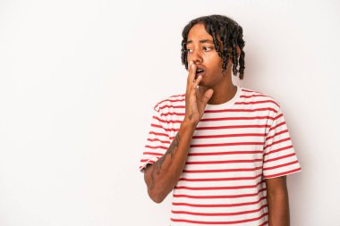 Beyaz arka planda izole edilmiş genç Afro-Amerikan bir adam gizli bir sıcak fren haberi veriyor ve kenara bakıyor.