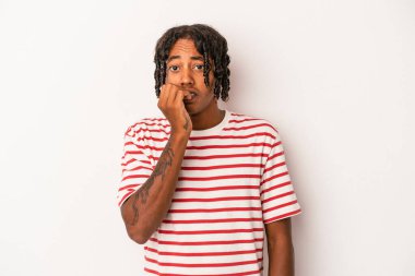 Genç Afrikalı Amerikalı bir adam beyaz arka planda izole edilmiş tırnak yiyor, gergin ve endişeli..