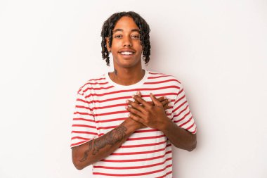 Beyaz arka planda izole edilmiş genç Afro-Amerikalı bir adam dost ifadesine sahip, avuçlarını göğsüne bastırıyor. Aşk konsepti.