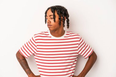 Beyaz arka planda izole edilmiş genç Afrikalı Amerikalı adam kafası karışmış, şüpheli ve güvensiz hissediyor..