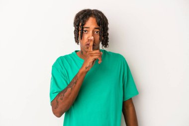 Beyaz arka planda izole edilmiş genç Afrikalı Amerikalı bir adam ya sır saklıyor ya da sessizlik istiyor..