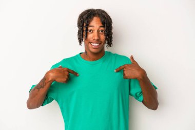 Beyaz arka planda izole edilmiş genç bir Afro-Amerikan erkeği parmağını gösterip gülümseyerek şaşırdı..