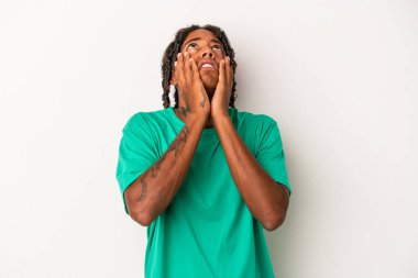 Genç Afrikalı Amerikalı, beyaz arka planda yalnız başına sızlanıyor ve ağlıyordu..