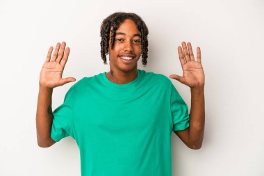 Beyaz arka planda izole edilmiş genç Afrikalı Amerikalı adam on numarayı elleriyle gösteriyor..
