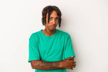 Beyaz arka planda izole edilmiş genç Afrikalı Amerikalı adam alaycı bir ifadeyle kameraya bakıyor..