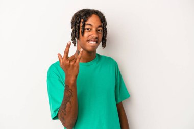 Beyaz arka planda izole edilmiş genç Afrikalı Amerikalı parmaklarıyla kaya hareketi gösteriyor.