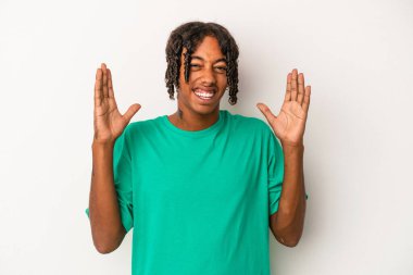 Genç Afrikalı Amerikalı bir adam beyaz arka planda neşeli bir şekilde gülüyor. Mutluluk kavramı.